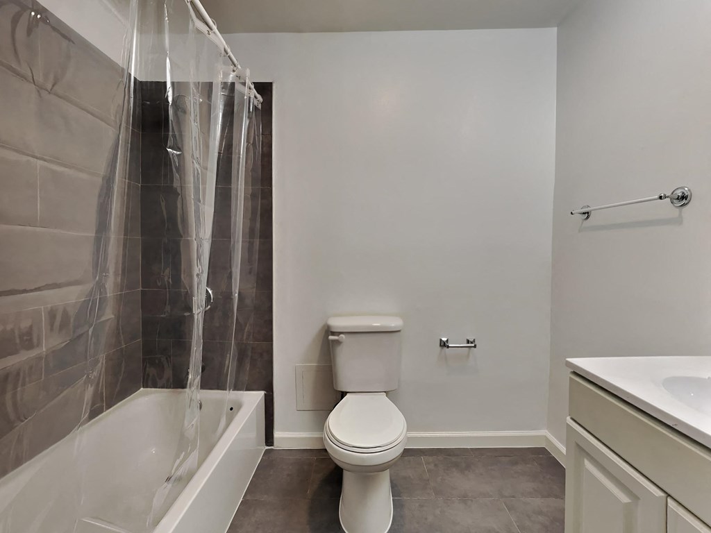 a bathroom with a shower and a toilet and a sink