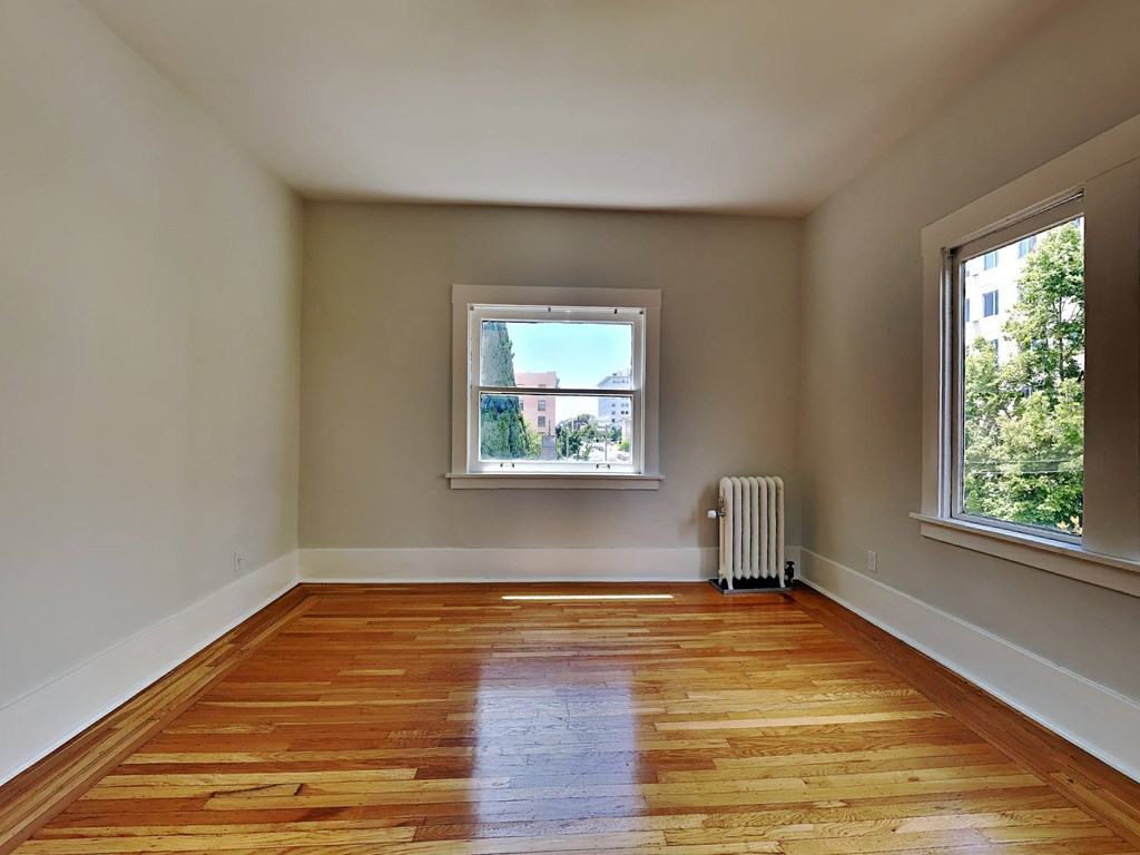 a empty room with a window and wooden floors