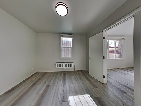 a living room with wood floors and a white door