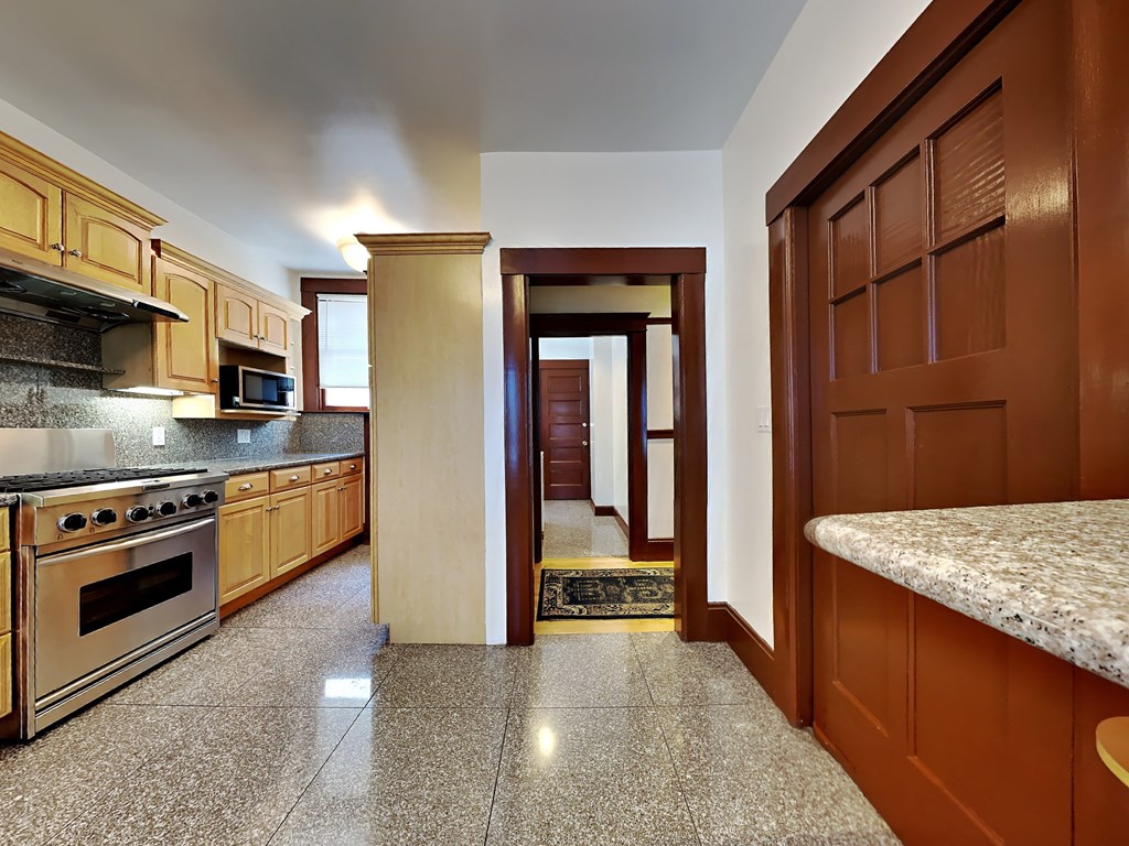 a kitchen with granite counter tops and wooden cabinets