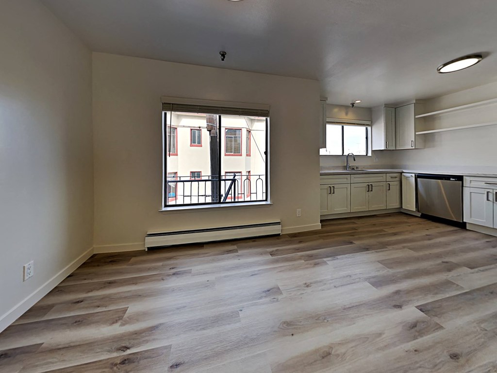 a renovated kitchen with white cabinets and a window