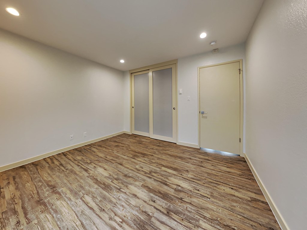 the living room of a new home with wood flooring and white walls
