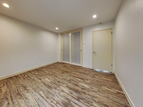 the living room of a new home with wood flooring and white walls