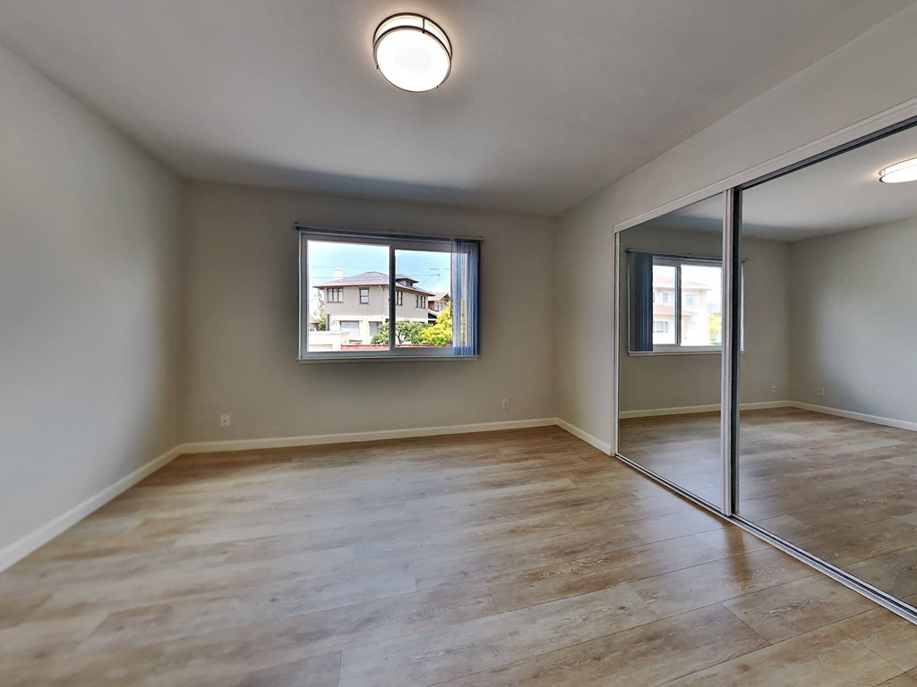 an empty living room with sliding glass doors and a window