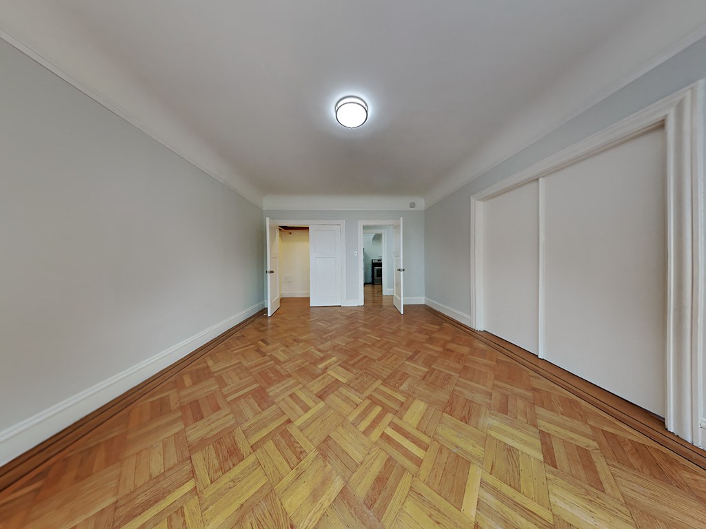 a living room with a hardwood floor and white walls
