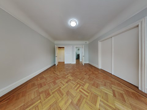 a living room with a hardwood floor and white walls
