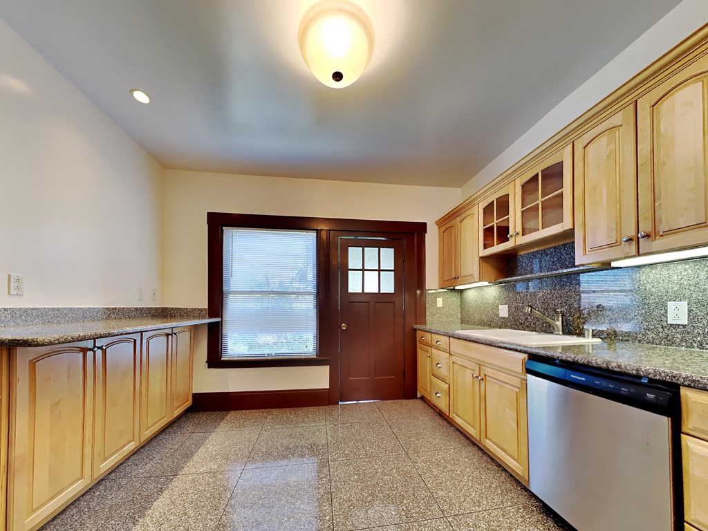 a kitchen with granite counter tops and wooden cabinets