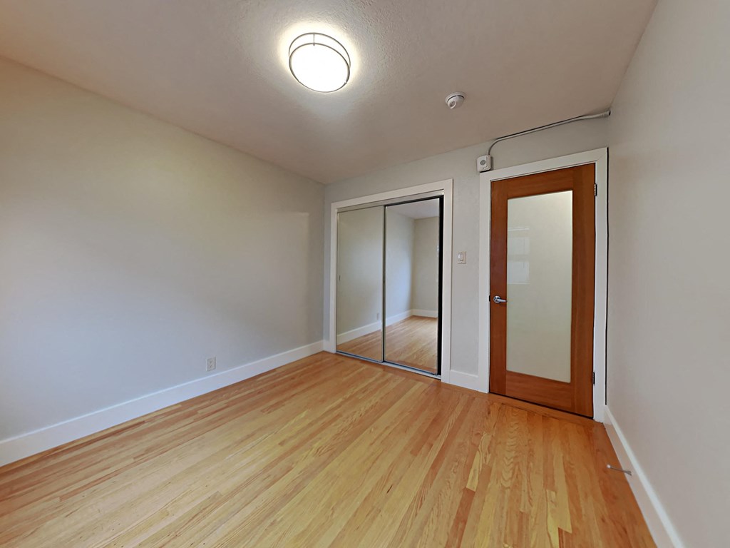 a living room with wood floors and a door to a closet