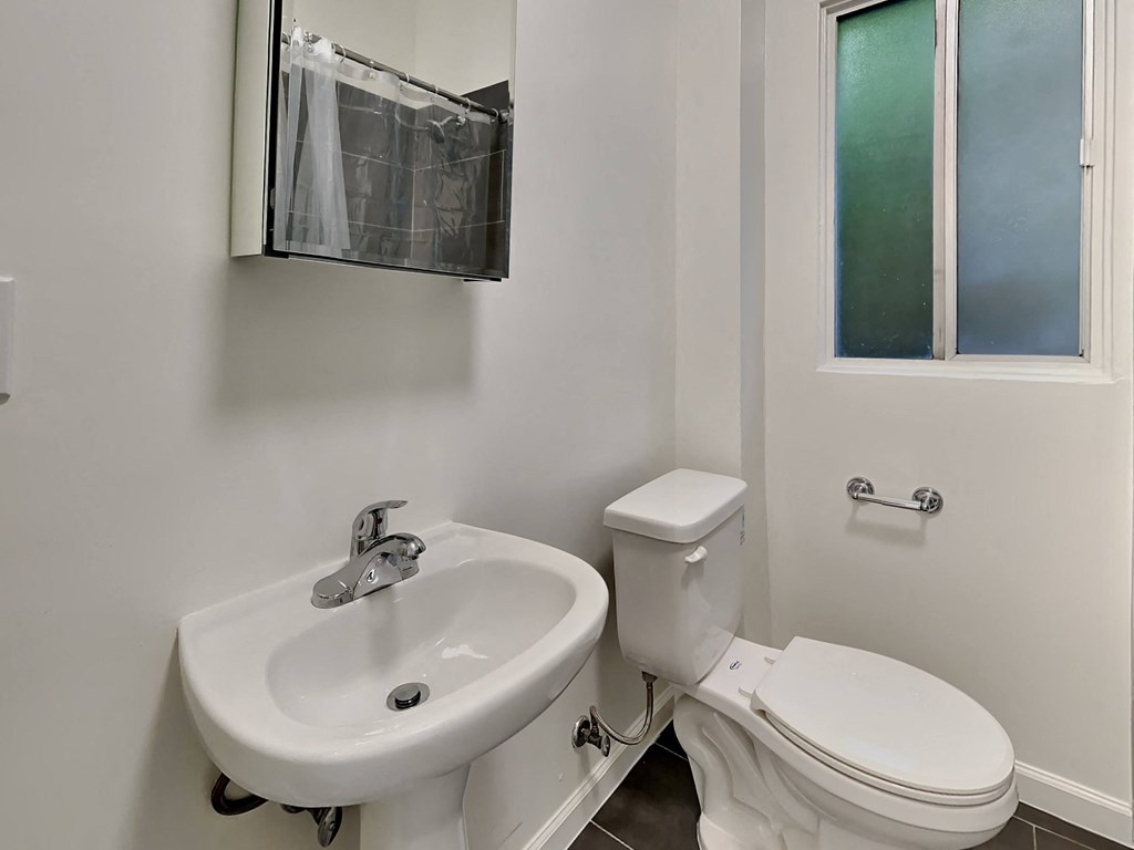 a bathroom with a sink toilet and a window