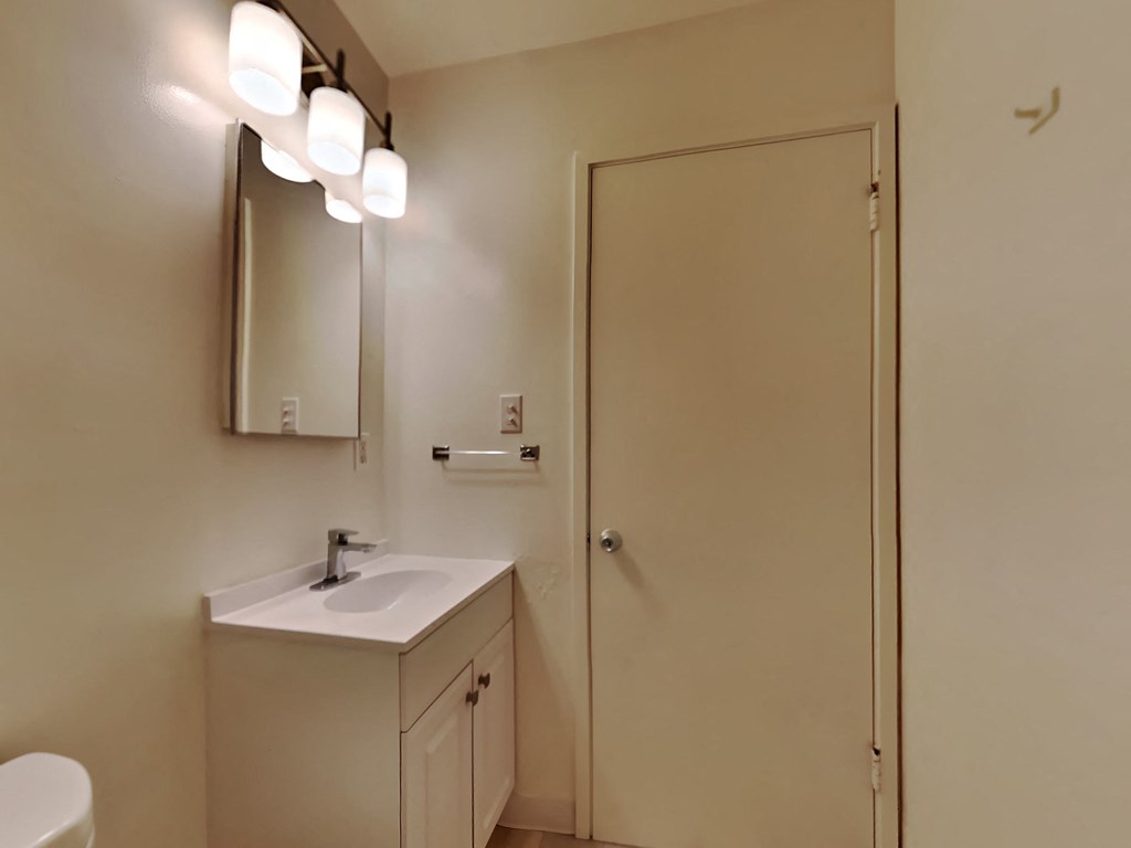 a bathroom with a sink and a mirror and a door