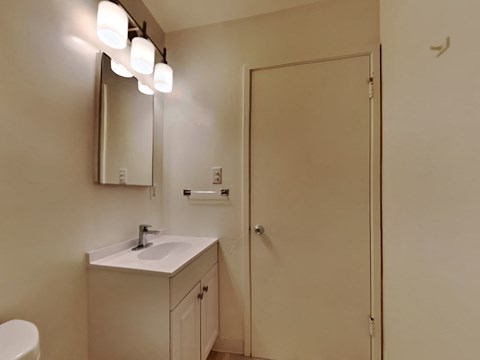 a bathroom with a sink and a mirror and a door