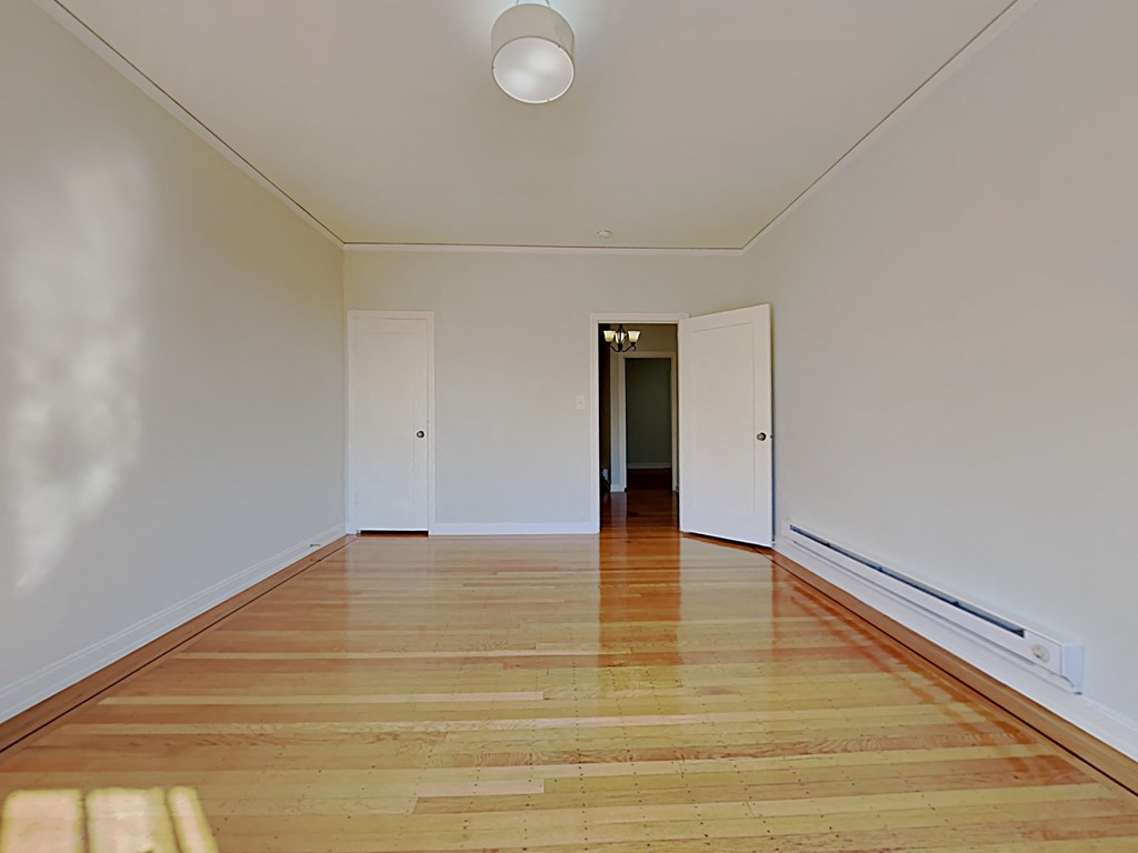 a living room with a hardwood floor and white walls