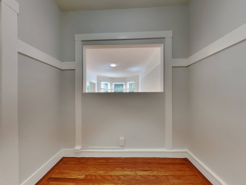 A room with a wooden floor and white walls.