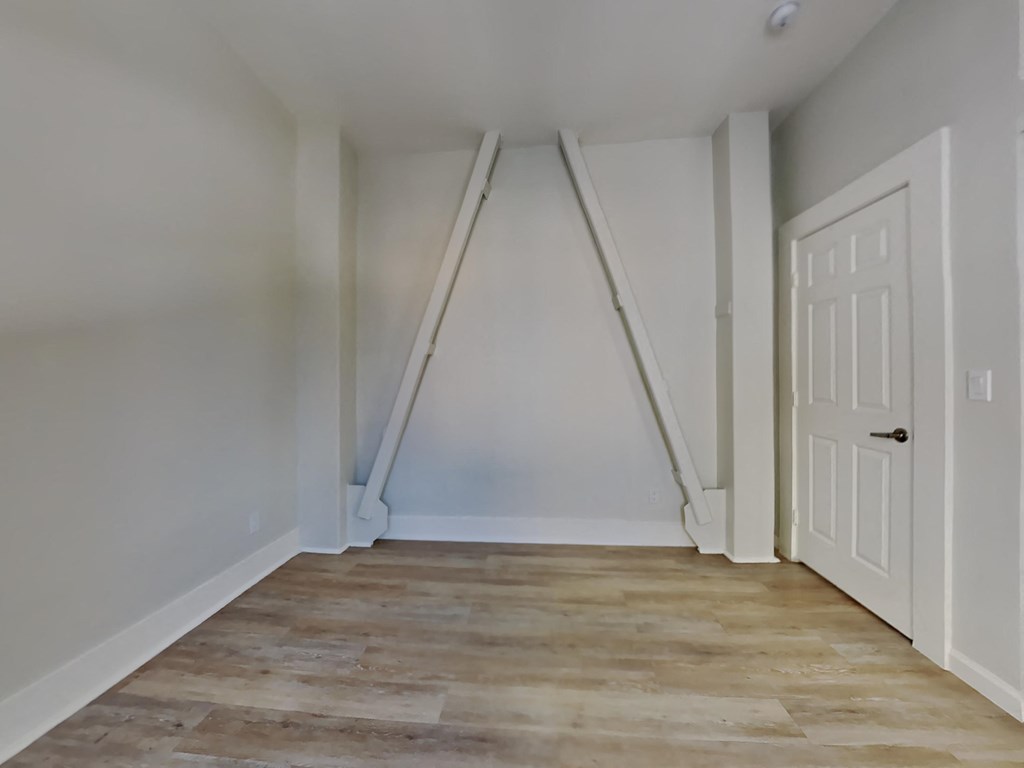 a room with a ladder in the wall and a door