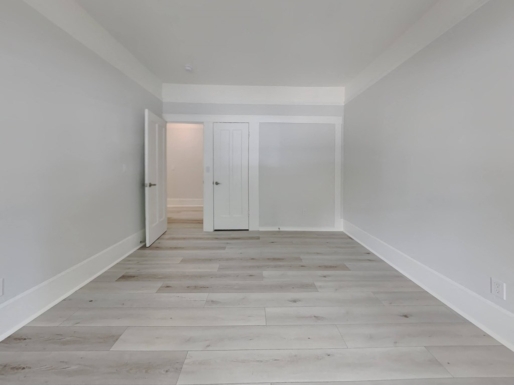 a brand new living room with white walls and wood floors
