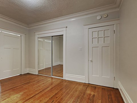 the living room of a house with white doors and wood floors