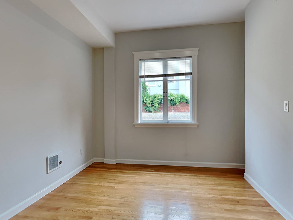 a living room with a window and wooden floors