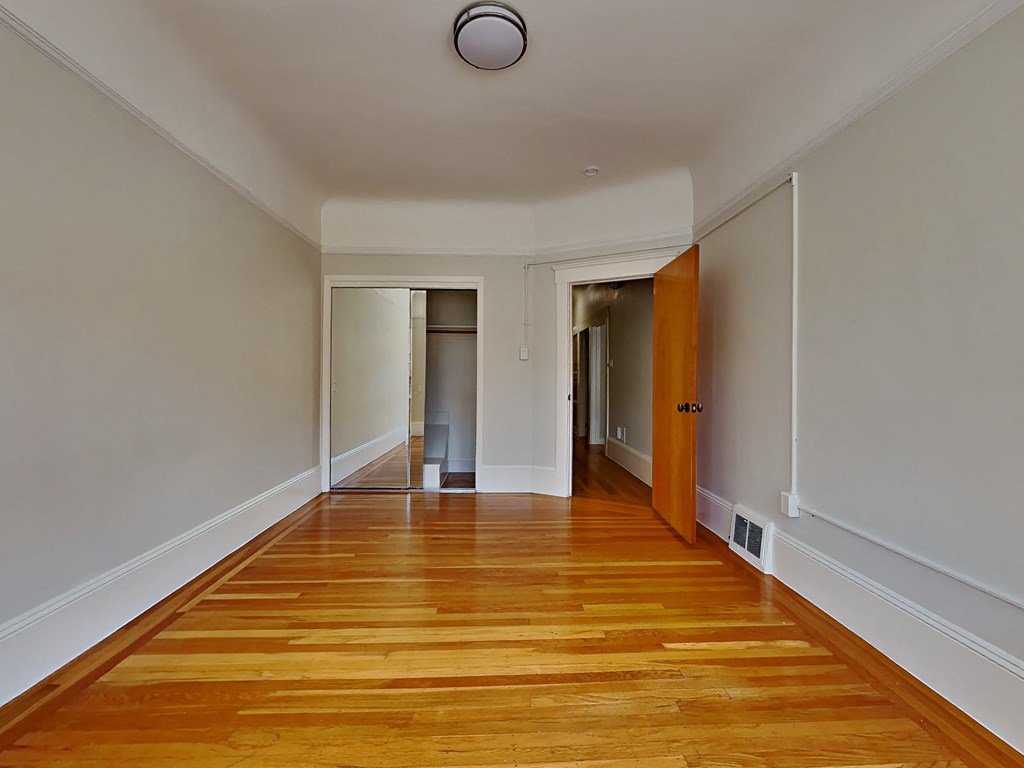a renovated living room with wood floors and white walls