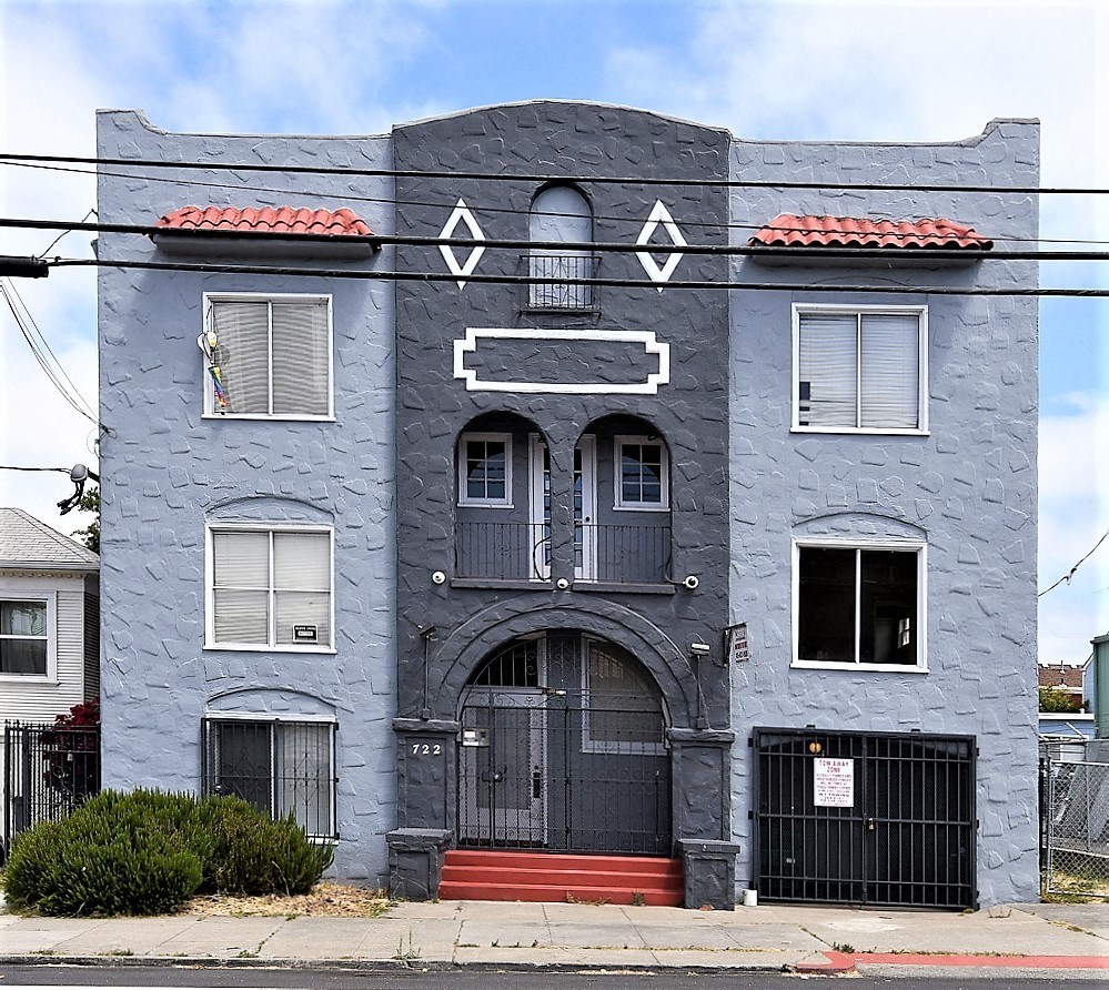 a blue house with a black door and a gray building