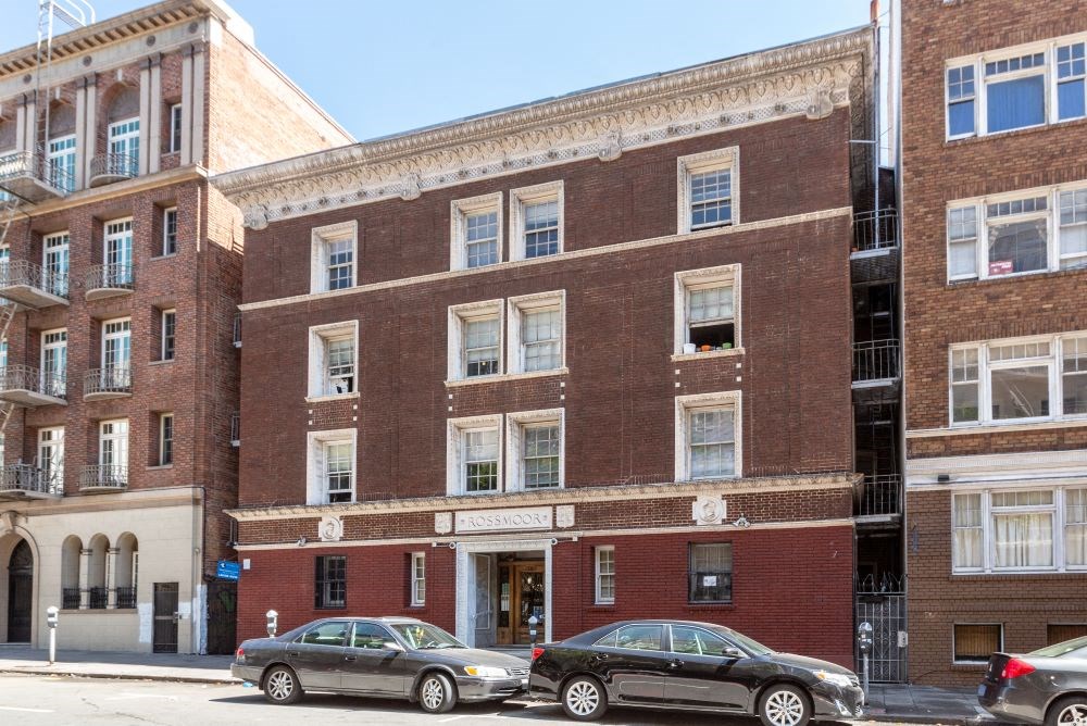 a brick building with cars parked in front of it
