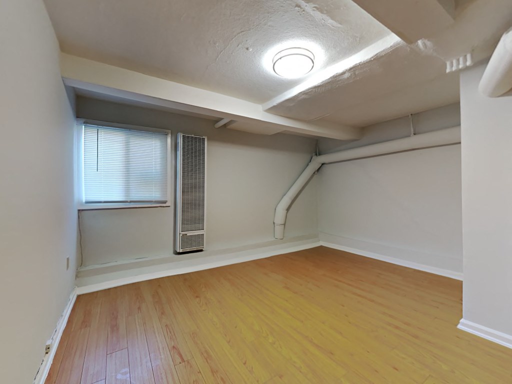 an empty living room with wood flooring and a window