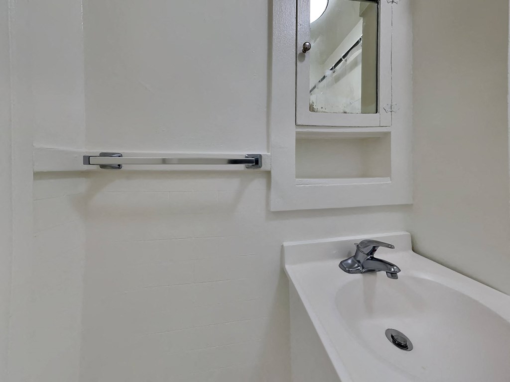 a white bathroom with a sink and a mirror