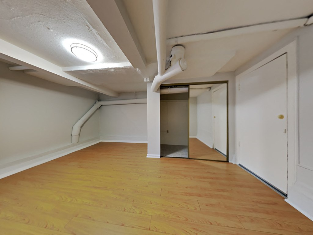 a living room with wood floors and white walls and a doorway