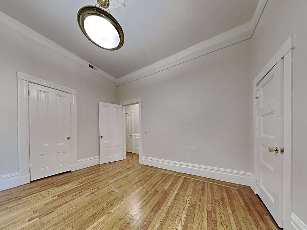 an empty living room with white walls and wood floors