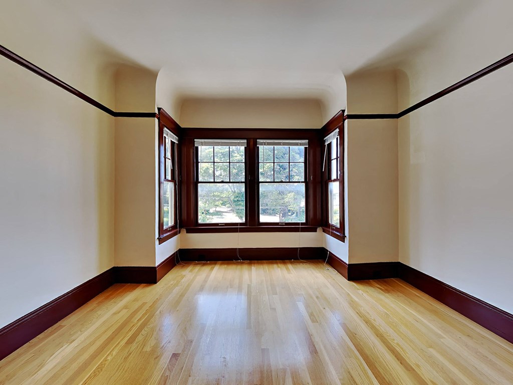 a empty room with wood floors and windows