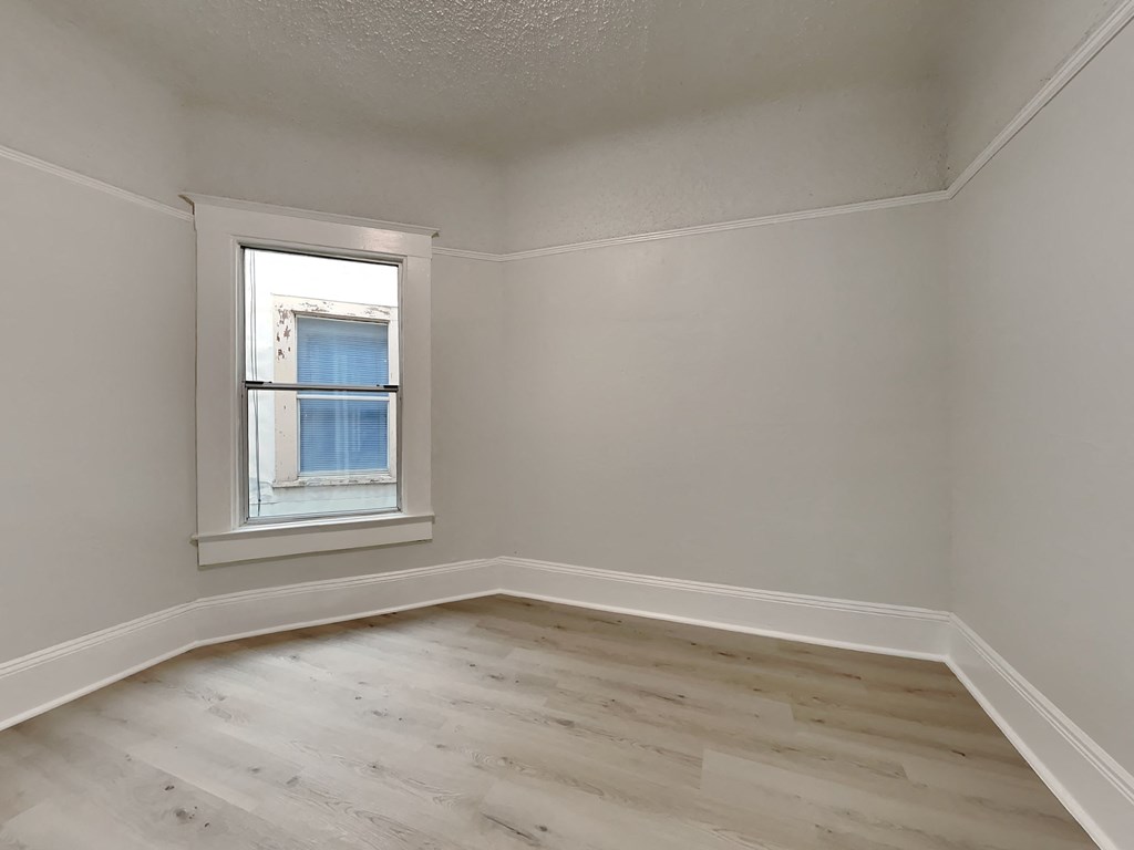 an empty room with white walls and a window