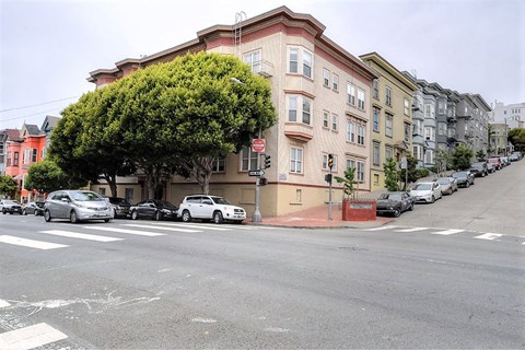 a city street with cars parked in front of a building