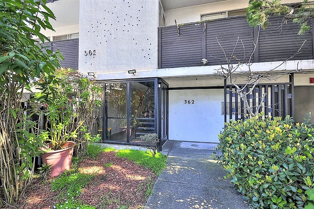the front door of a house with a yard and plants