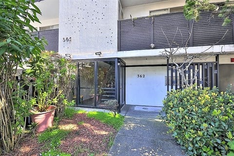 the front door of a house with a yard and plants