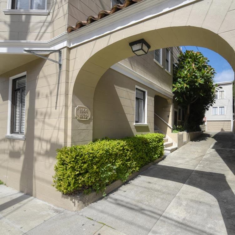 a building with an archway in front of a sidewalk