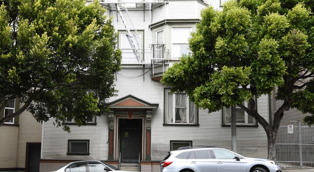 a white house with two cars parked in front of it