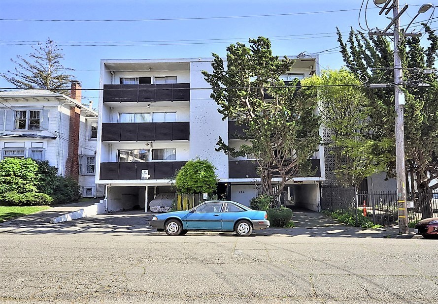 a blue car parked in front of an apartment building