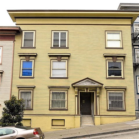 a yellow house with a car parked in front of it