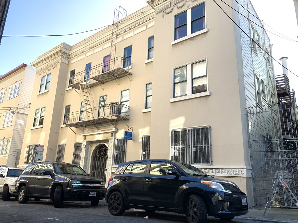 a city street with cars parked in front of a building