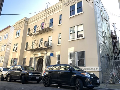 a city street with cars parked in front of a building