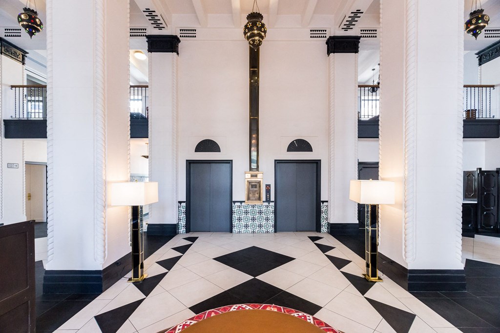 a view of the lobby of a building with columns and a black and white floor