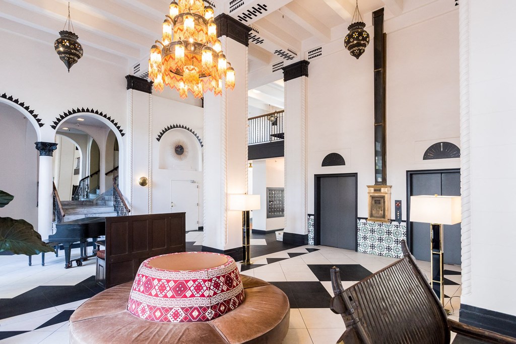a living room with a round table and chairs and a chandelier
