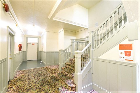 the lobby of a building with stairs and a door