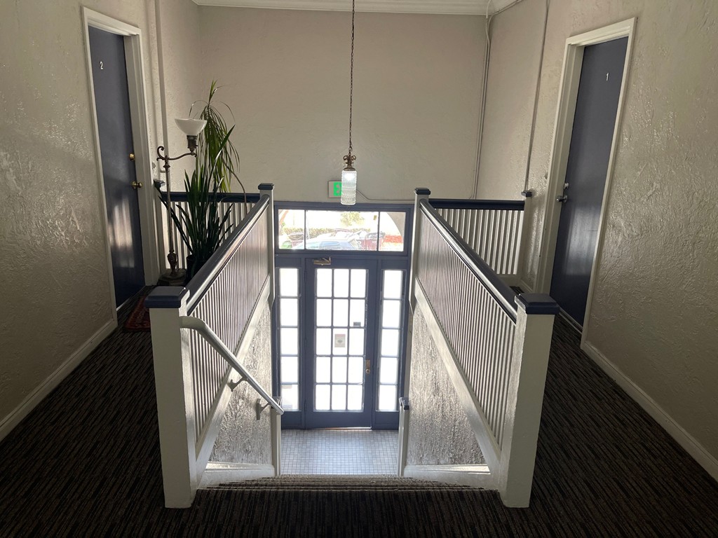 a stairway with a glass door and a pendant light