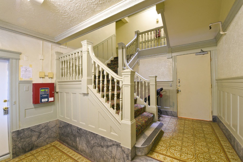 a stairwell in a house with a white staircase and a door