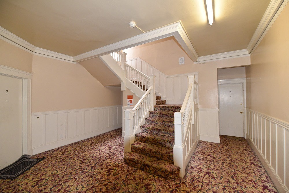 the landing of a staircase in a home with a carpeted floor