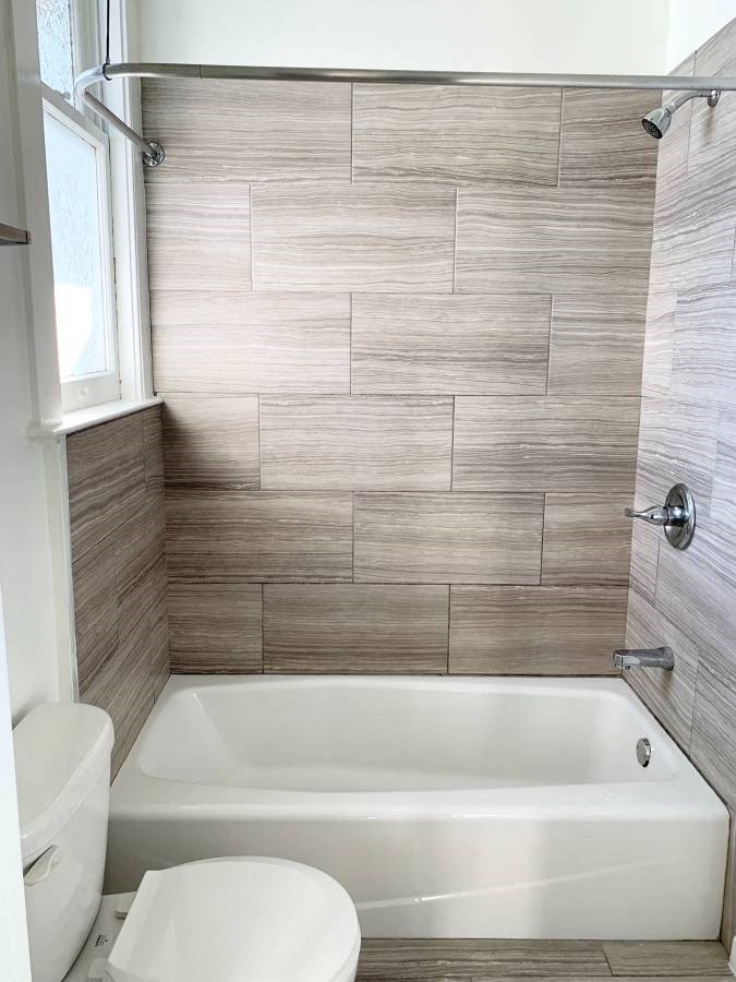 a bathroom with a toilet and a bath tub