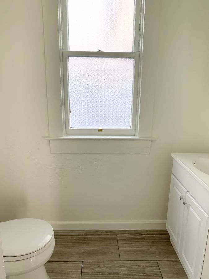 a bathroom with a toilet and a window
