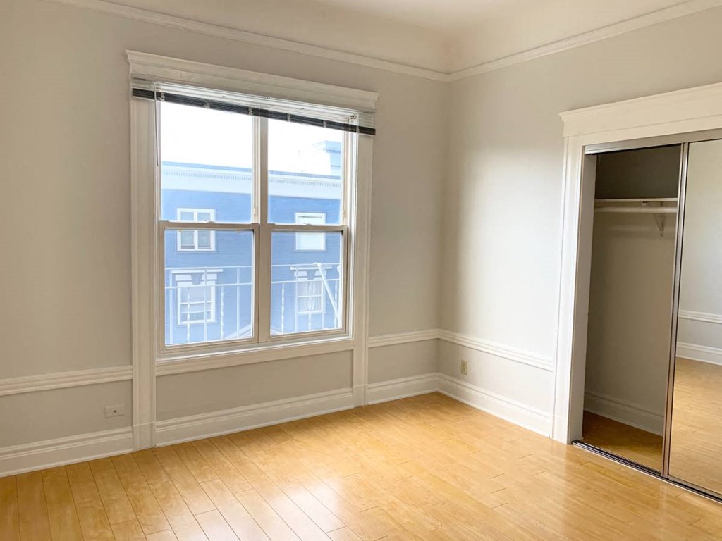 an empty room with a window and a closet
