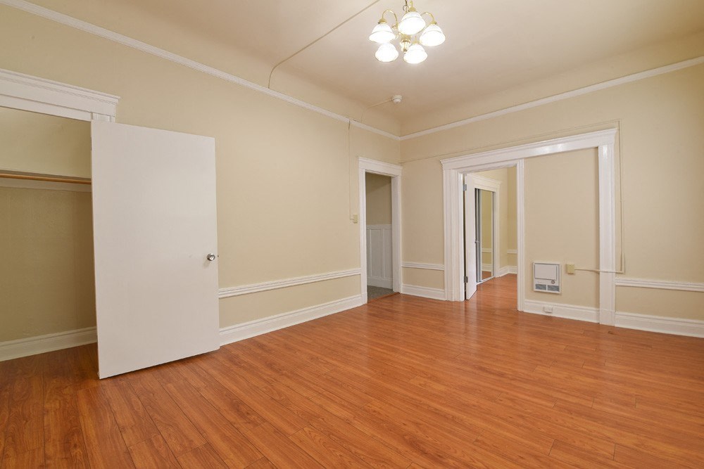 a empty living room with wood floors and a white door