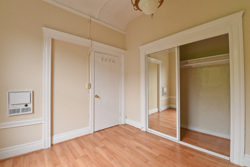 a living room with white doors and a wood floor